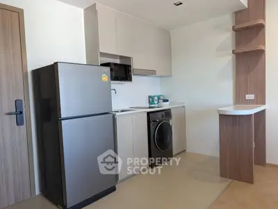 Modern kitchen with sleek appliances and stylish cabinetry in a contemporary apartment.