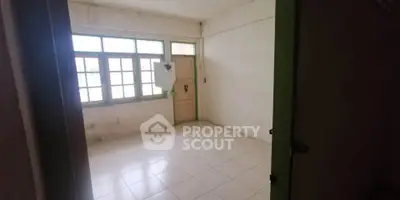 Spacious empty room with tiled floor and large windows, ideal for customization.