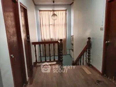 Charming vintage hallway with wooden floors and classic railing, perfect for a cozy home renovation project.