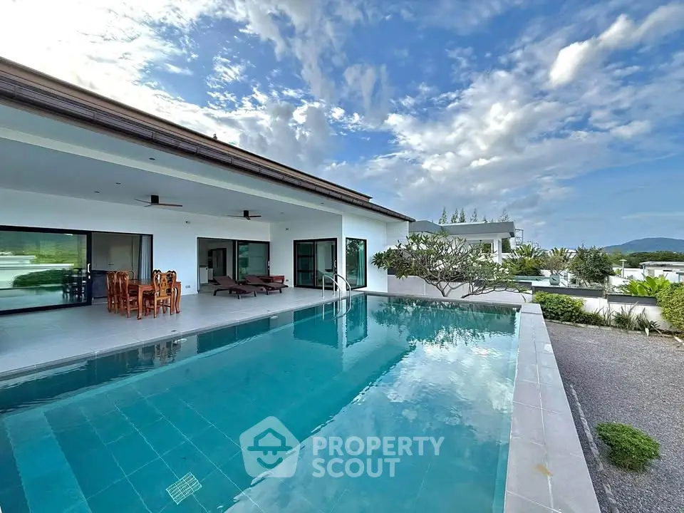 Luxurious villa with stunning pool and modern architecture under a vibrant sky.