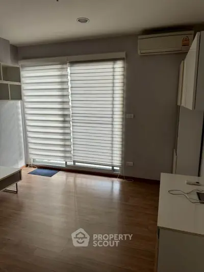 Modern living room with wooden flooring and large window blinds