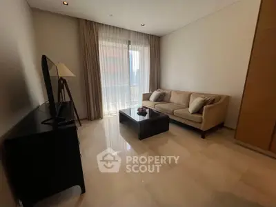 Modern living room with elegant sofa and natural light from large window.