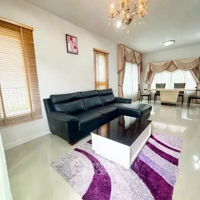 Elegant living room with black leather sofa, modern chandelier, and stylish decor in a spacious home.