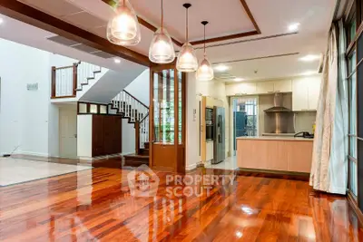 Spacious open-plan living area with modern kitchen and gleaming wooden floors.
