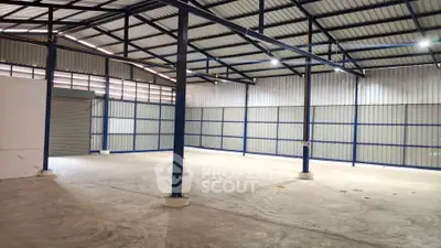 Spacious industrial warehouse with high ceilings and ample natural light, ideal for storage or manufacturing.