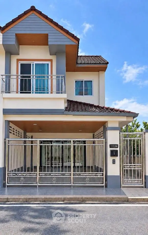 Modern two-story house with gated entrance and balcony, perfect for family living.