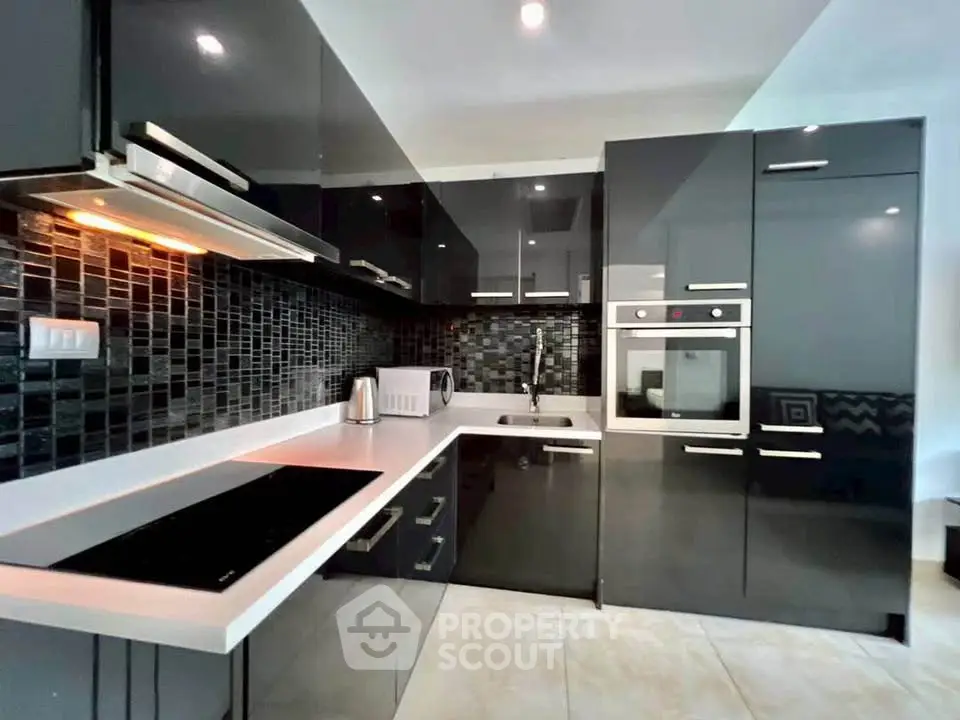 Modern kitchen with sleek black cabinetry and built-in appliances