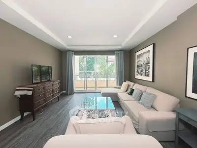 Spacious living room with elegant decor and large windows offering natural light.