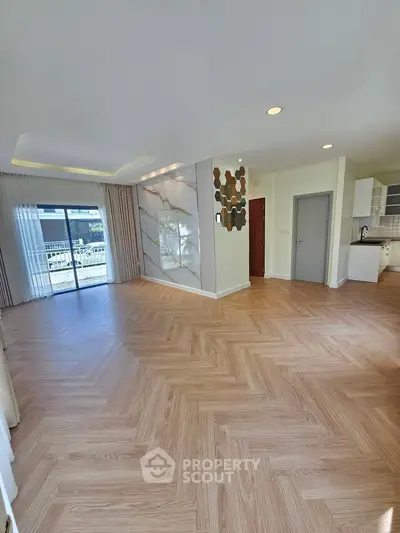 Spacious modern living room with elegant flooring and large windows for natural light.