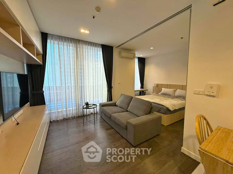 Modern studio apartment with open layout, featuring cozy living area and elegant bedroom, perfect for urban living.