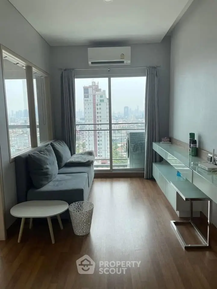 Modern living room with city view, featuring sleek furniture and large windows for natural light.