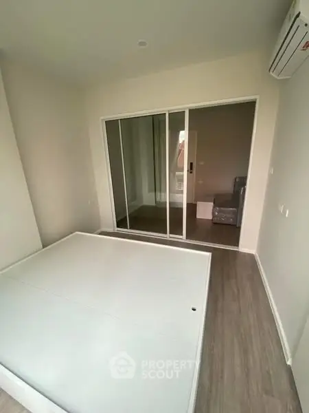 Modern bedroom with mirrored closet and air conditioning in a stylish apartment.