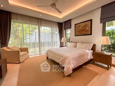 Luxurious bedroom with garden view, featuring elegant decor and natural light.