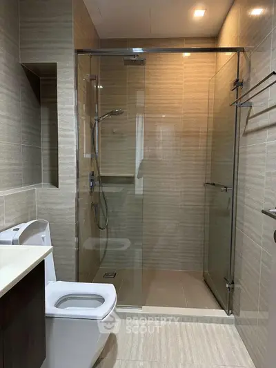 Modern bathroom with glass shower enclosure and sleek fixtures