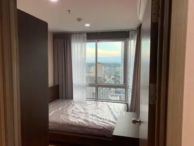 Modern bedroom with city view and large window, perfect for urban living.