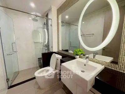 Modern bathroom with illuminated mirror and glass shower enclosure