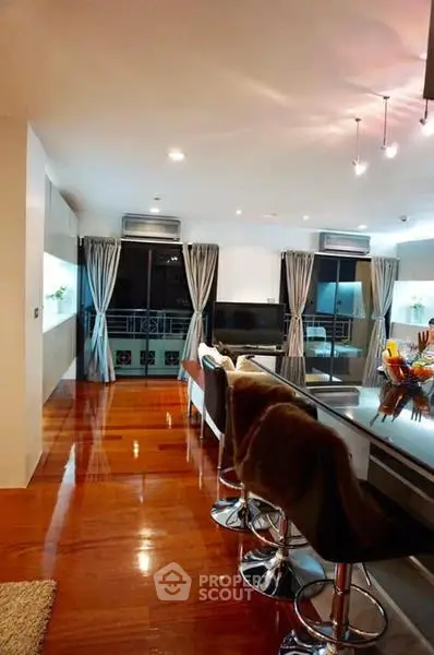 Luxurious open-plan living room with sleek kitchen and polished wooden floors