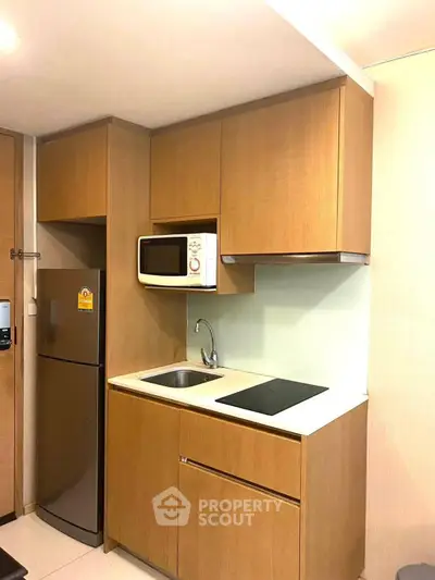 Modern compact kitchen with wooden cabinets and built-in appliances