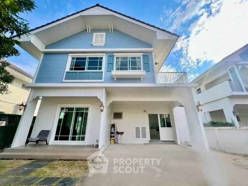 Charming two-story blue house with spacious driveway and modern design.