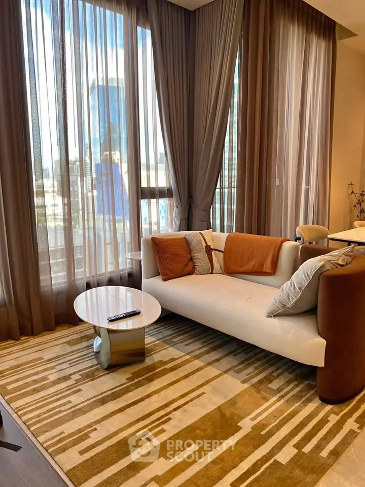 Luxurious living room with modern sofa, stylish rug, and floor-to-ceiling windows offering city views.