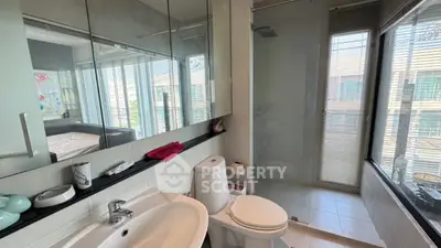 Modern bathroom with sleek fixtures and large windows offering natural light.