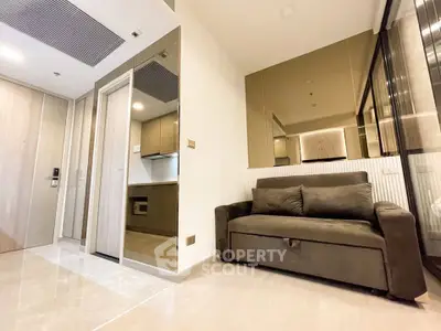 Modern apartment interior with sleek kitchen and cozy living area, featuring a stylish sofa and contemporary design.