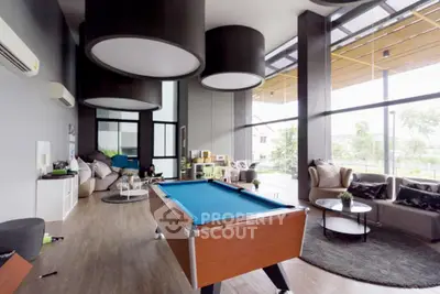 Spacious modern living room with pool table and large windows