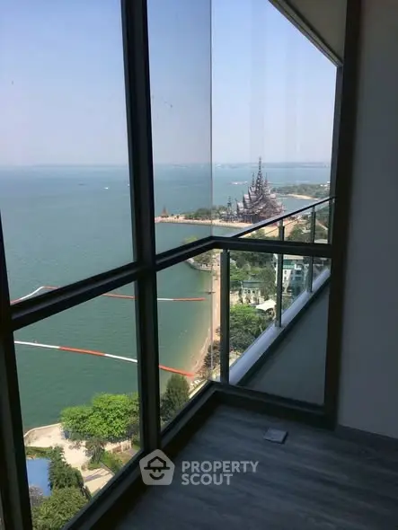 Stunning high-rise balcony view overlooking serene ocean and iconic landmark.