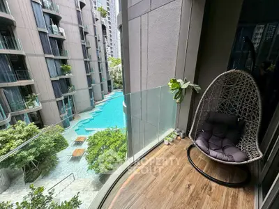 Luxurious balcony with stunning pool view in modern high-rise apartment.