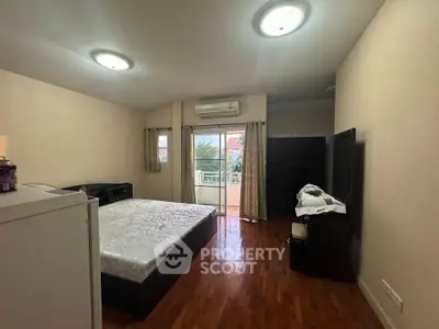 Spacious bedroom with balcony access and wooden flooring