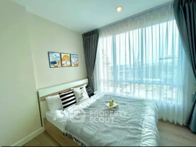 Bright and cozy bedroom with large window and modern decor in a stylish apartment.