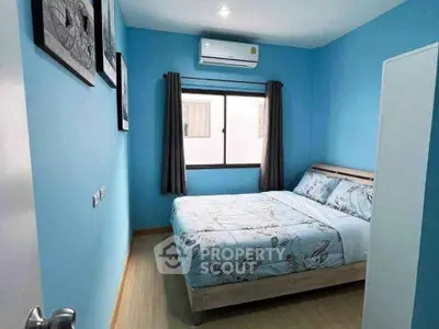 Cozy blue-themed bedroom with modern decor and natural light.