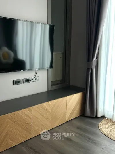 Modern living room with sleek TV setup and elegant curtains