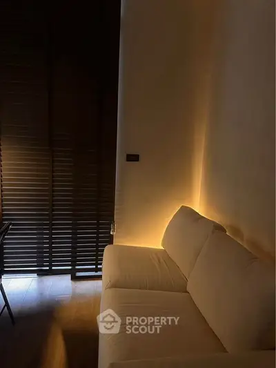 Cozy living room with ambient lighting and modern blinds, perfect for relaxation.
