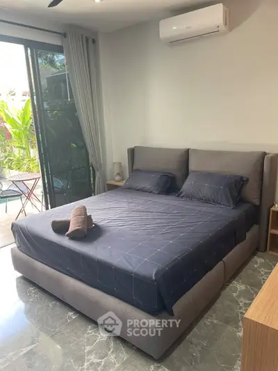 Luxurious bedroom with modern decor and garden view, featuring a plush bed and elegant marble flooring.