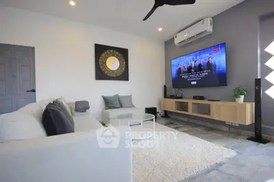 Modern living room with stylish decor and wall-mounted TV, perfect for entertainment.