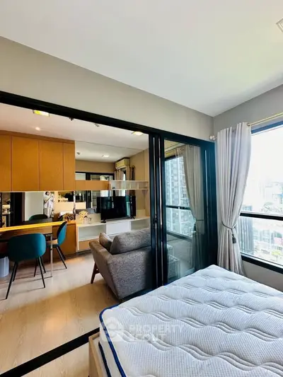 Modern apartment with open layout, featuring a cozy living area and city view from the bedroom.