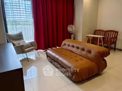 Stylish living room with modern furniture and large window offering natural light.