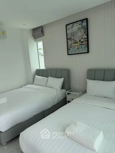 Modern bedroom with two beds and stylish decor in a bright apartment.
