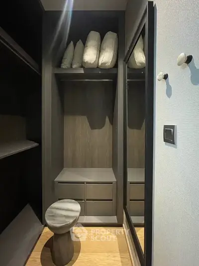 Stylish modern walk-in closet with sleek shelving and elegant stool