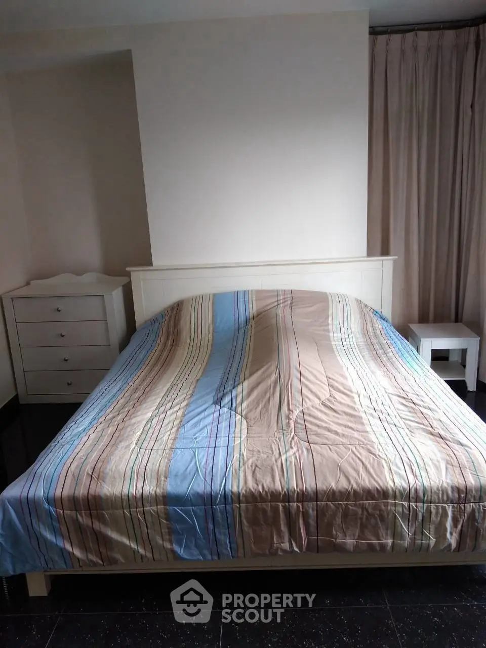 Cozy bedroom with striped bedding and minimalist furniture