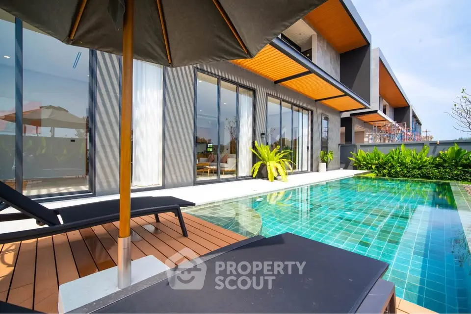Luxurious modern villa with private pool and sun loungers, perfect for relaxation and entertainment.