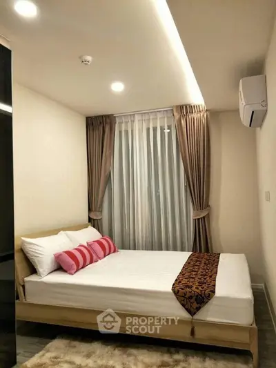 Cozy bedroom with modern decor and natural light, featuring a comfortable bed and elegant curtains.