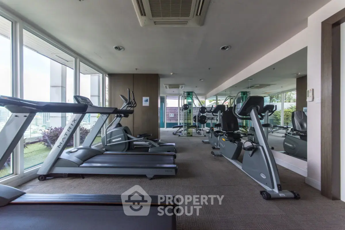 Modern gym with state-of-the-art equipment and large windows for natural light.