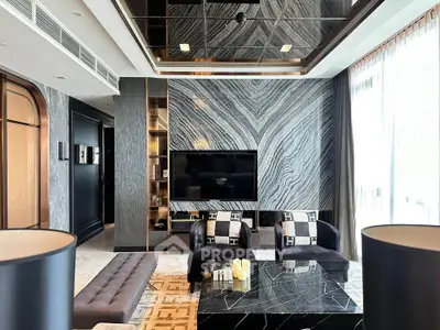 Luxurious modern living room with elegant marble wall and sleek furniture design.