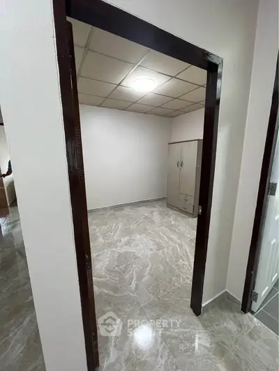 Spacious room with marble flooring and modern wardrobe in a stylish apartment.