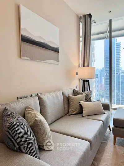 Modern living room with stylish decor and city view, featuring a comfortable gray sofa and elegant lighting.