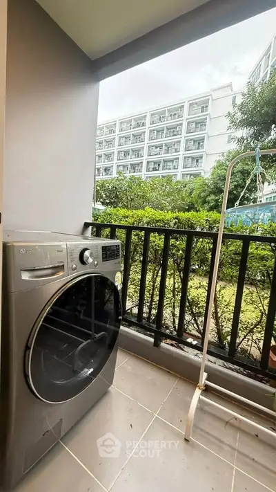 Modern balcony with washing machine and garden view in urban apartment