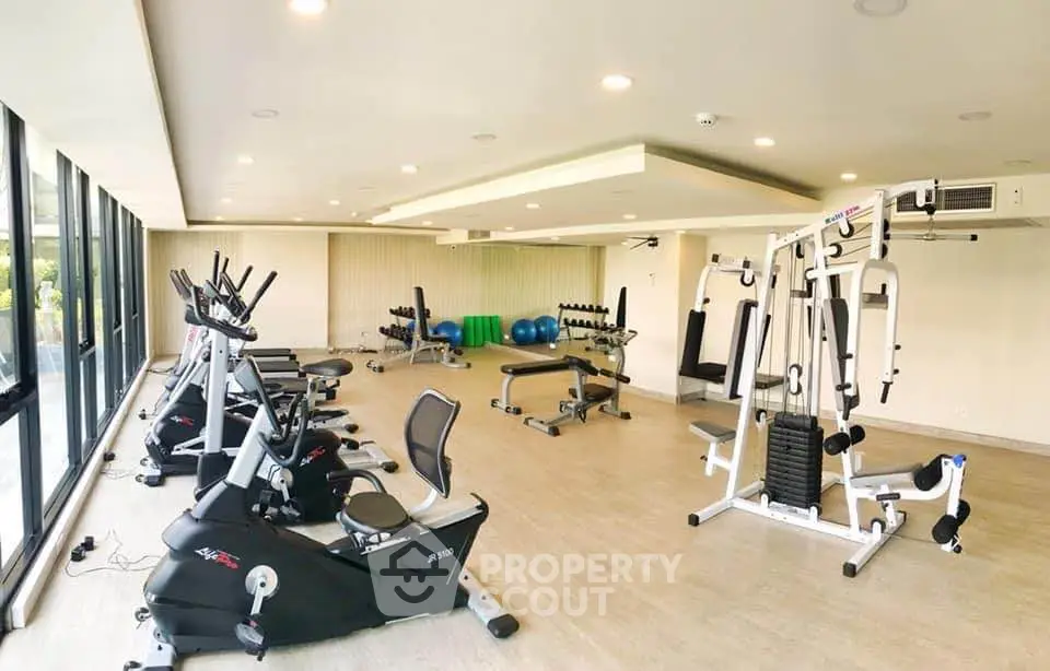 Spacious modern gym with state-of-the-art fitness equipment and large windows.