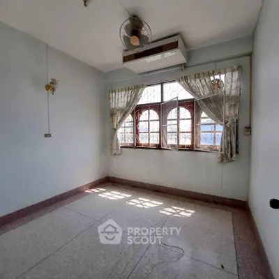 Spacious empty room with large windows and natural light, ideal for customization.